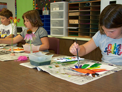 Picture of students painting artwork in a classroom