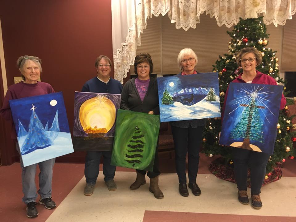 Picture of ladies holding up winter theme canvas paintings